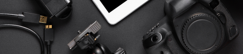 Câmera fotográfica ao lado de acessórios e dispositivos que compõem um setup de fotografia profissional.