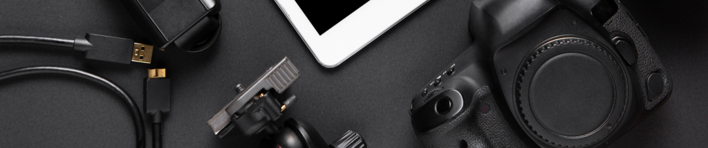 Câmera fotográfica ao lado de acessórios e dispositivos que compõem um setup de fotografia profissional.